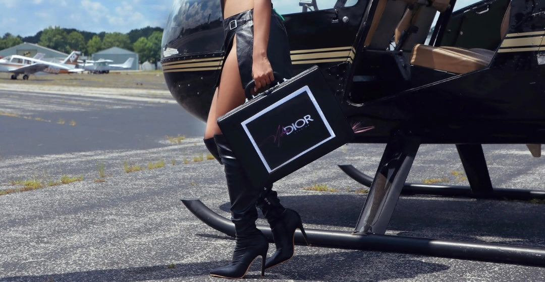 Asha holding her branded briefcase beside a helicopter